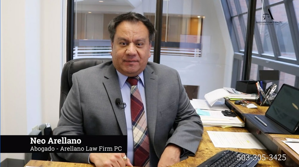 Attorney Neo Arellano, founder of Arellano Law Firm PC, sitting at his desk and addressing clients, offering trusted legal representation in Oregon